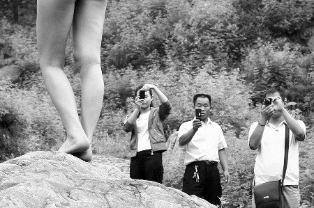 村民持樹枝驅趕拍寫真裸女 稱丟人現眼(組圖)
