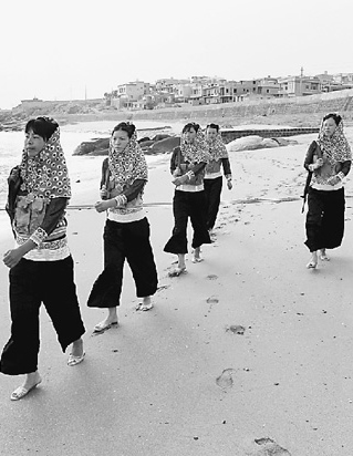 女民兵們身著傳統(tǒng)的惠安女服飾巡視海岸。 　　本報記者 朱 磊攝