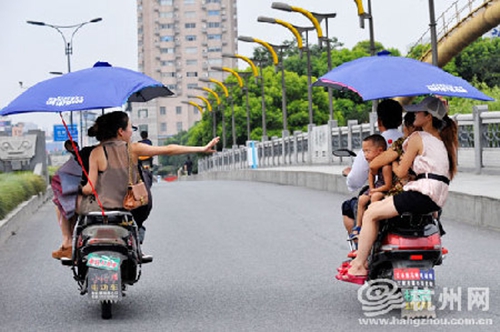 違規(guī)加裝遮陽(yáng)傘的電動(dòng)車(chē)，易翻車(chē)還危及行人安全（資料圖）